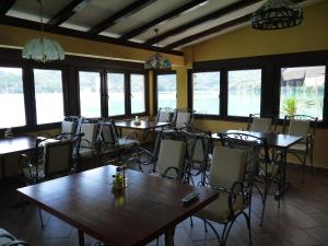 a dining room with tables and chairs and windows at Pansion Asim in Jablanica