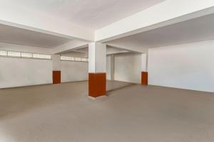 an empty room with white walls and orange columns at Treebo Prime Bliss Whitefield in Bengaluru +25 photos