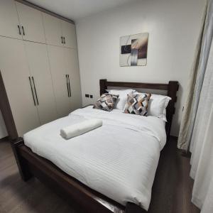 a bedroom with a large bed with white sheets and pillows at Golden mango heights in Nairobi