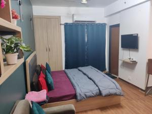 a bedroom with a bed with a blue curtain at Dristy homez in Noida