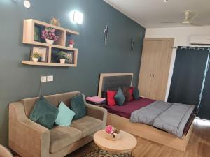 a living room with a couch and a bed at Dristy homez in Noida