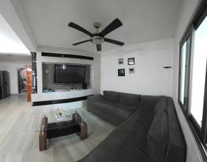 ein Wohnzimmer mit einer Couch und einem Deckenventilator in der Unterkunft Casa, Habitación, Alojamiento, Estancia- in Chiapa de Corzo