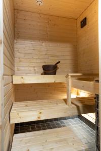 a wooden sauna with a bucket on a shelf at Vanhamylly AS 4 in Äkäslompolo