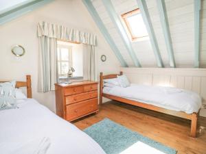 a bedroom with two beds and a window at Dovecote in Saint Goran