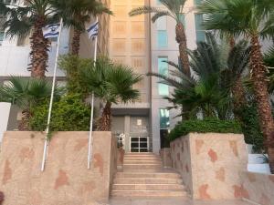 a group of palm trees in front of a building at Eilat Luxury Vacation -Amazing Pool in Eilat