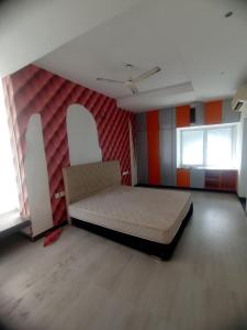 an empty room with a bed and two windows at Sharmila residency in Mahabalipuram +8 photos