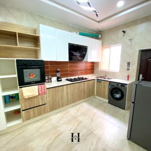 a kitchen with a stove and a washing machine at OTMO Haven in Lagos