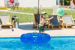 a young boy playing in the water in a pool at Dolinnka Hotel in Cholpon-Ata