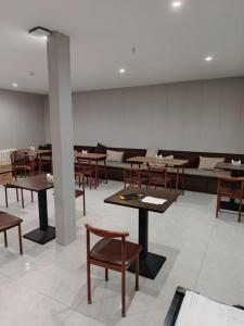 een kamer met tafels en stoelen en een bank bij Zhongmai Yunting Hotel in Harbin