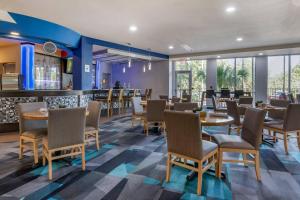 a restaurant with tables and chairs and a bar at Cambria Hotel Ft Lauderdale, Airport South & Cruise Port in Dania Beach