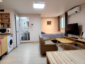 首尔Neovill的一间带床的卧室和一间带桌子的客厅 更多123张照片