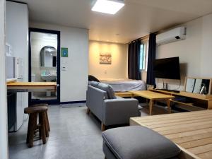 首尔Neovill的客厅里有一张沙发、一张床和一张桌子