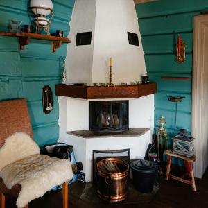 a living room with a fireplace with green walls at Restored Cabin From 1852 In Bergsjø Area in Skarsgård +7 photos