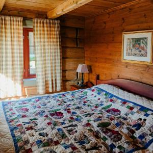a bed in a room with a quilt on it at Restored Cabin From 1852 In Bergsjø Area in Skarsgård