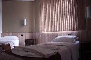 a hotel room with two beds and a window at Hotel Domus Itabira in Itabira +28 photos