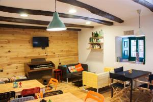 a living room with wooden walls and a piano at Hotel Rural Casa Indie in Rabanal del Camino