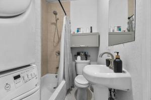 a small bathroom with a toilet and a sink at 4 Bedroom Modern Luxe Retreat with Hot Tub 5 Mins to Beach in West Palm Beach +103 photos