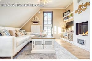un soggiorno con un divano e un tavolo di FEWO MW8 Zingst - 5min zum Strand - Ostseefeeling & hochwertige Küchenausstattung a Zingst