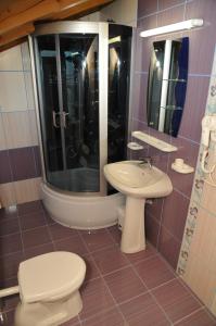 La salle de bains est pourvue de toilettes et d'un lavabo. dans l'établissement Pensiunea Lory, à Piatra Neamţ