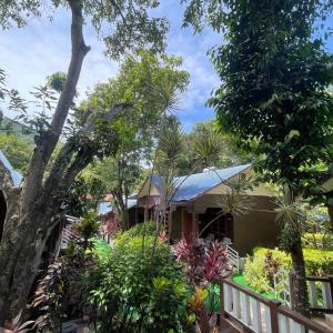 ein von Bäumen und Pflanzen umgebenes Haus in der Unterkunft Sha-Rilla Perhentian Resort in Kampong Pasir Panjang