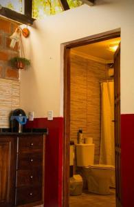 a bathroom with a toilet and a sink and a cabinet at Casitas Nuova Villa in Puerto Iguazú