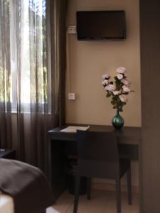 una stanza con un tavolo e un vaso di fiori di Locanda Del Conventino a Lugano