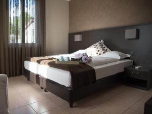 una camera da letto con un letto grande con testiera in legno di Locanda Del Conventino a Lugano