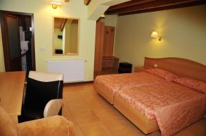 una camera con letto, tavolo e sedia di Pensiunea Lory a Piatra Neamţ