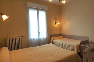 Giường trong phòng chung tại Hôtel Hélios