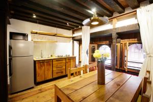 a kitchen with a wooden table and a refrigerator at The Newari dream in Old Patan-high ceiling & charm in Pātan