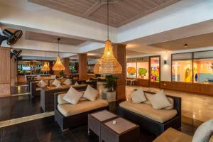 a lobby with couches and a bar in a restaurant at Best Western Premier Bangtao Beach Resort & Spa in Bang Tao Beach