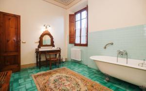 Un baño con bañera, lavabo y espejo. en Villa Dolciano, en Chiusi