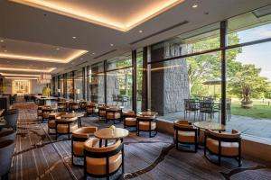 a restaurant with tables and chairs and windows at Hilton Odawara Resort & Spa in Odawara +92 photos