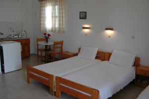 a bedroom with a large bed and a kitchen at Albatross in Marathokampos