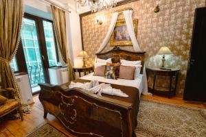a bedroom with a large bed with a canopy at Hotel Coroana Moldovei in Slănic-Moldova