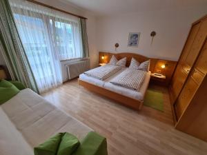 a bedroom with a bed and a large window at Landhaus KitzAlp (Alpenheim) in Brixen im Thale