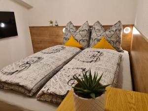 a bed with two pillows and a plant on it at Landhaus KitzAlp (Alpenheim) in Brixen im Thale