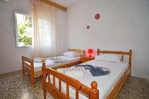 two twin beds in a room with a window at To Pithari in Skala Marion