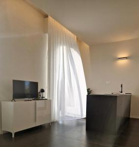 Appartamento sul molo - fra mare e Toscana في فياريجيو: غرفة معيشة فيها تلفزيون ونافذة كبيرة