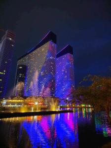a large building with blue and purple lights on it at Orbi City Premium Sea View Apartments in Batumi