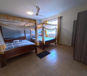 a bedroom with two bunk beds and a window at Haven Homes one bedroom in Diani Beach