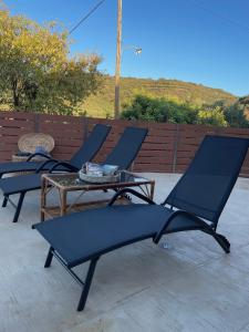 four lounge chairs and a table on a patio at Wild Tulip Escape in Kolymvari
