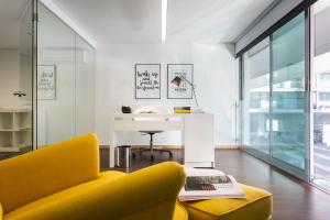 sala de estar con sofá amarillo y mesa en Aveiro Urban Loft, en Aveiro