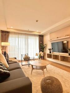 a living room with a couch and a table and a television at 3BD3BA Condo|City View|Hot Tub|7-11, PoolGym, Mall in Makkasan