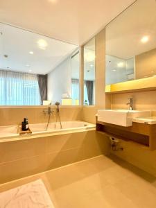 a bathroom with two sinks and a tub and a mirror at 3BD3BA Condo|City View|Hot Tub|7-11, PoolGym, Mall in Makkasan