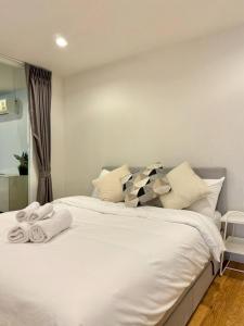 a bedroom with a large white bed with towels on it at 3BD3BA Condo|City View|Hot Tub|7-11, PoolGym, Mall in Makkasan
