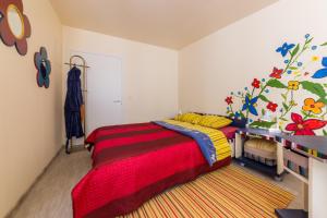 a bedroom with a bed with a red and yellow blanket at City Center Garden Camping in Tallinn