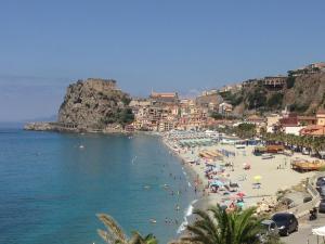 einen Strand mit Menschen im Wasser und in Gebäuden in der Unterkunft Casa Indipendente in Villa San Giovanni