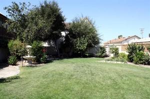 a yard with a green lawn with trees and houses at Royal Copenhagen Inn in Solvang