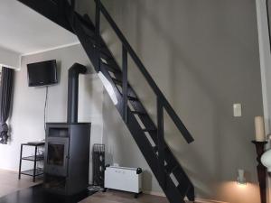 escalera en una sala de estar con estufa de leña en NEU! Ferienhütte Ahaus, en Ahaus 4 fotos más